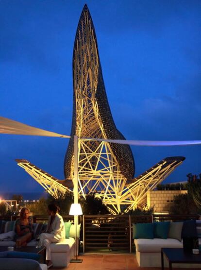 La estatua 'Pez Dorado' de Frank Gehry preside desde la cercana distancia la Terraza Arola del Hotel Arts, donde la cocina de marca de Sergi Arola se combina con un ambiente informal