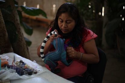 Una artesana decora los alebrijes realizados en el taller de Jacobo y María Angeles.