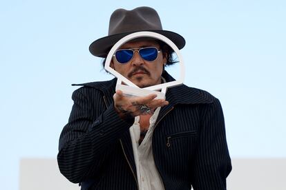 Depp plays with the San Sebastian film festival logo in front of photographers.