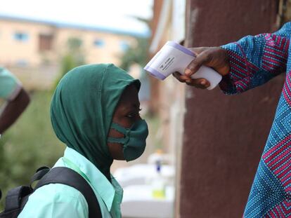 Toma de temperatura a un estudiante a las puertas de una escuela secundaria en Lagos (Nigeria): 