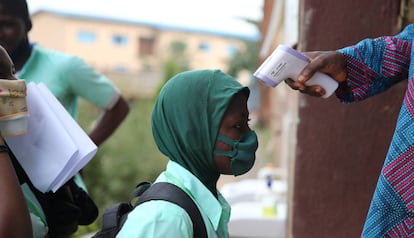 Toma de temperatura a un estudiante a las puertas de una escuela secundaria en Lagos (Nigeria): 