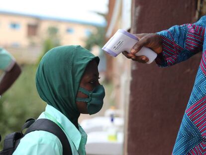Toma de temperatura a un estudiante a las puertas de una escuela secundaria en Lagos (Nigeria):