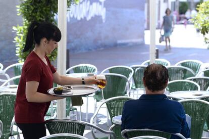 Una camarera sirve una cerveza en una terraza de Valladolid.