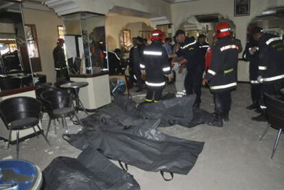 Miembros de los equipos de rescate, junto a los cuerpos de algunas víctimas mortales en el café Argana.