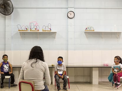 Una maestra da clase a tres de sus alumnos, todos separados por la distancia mínima de seguridad, en una escuela de educación primaria de São Paulo, en Brasil.