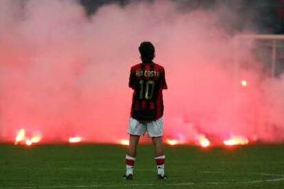 Rui Costa observa la lluvia de bengalas que lanzaron los seguidores del Inter.