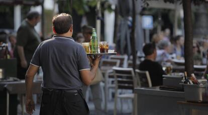 Un camarero sirviendo bebidas en una terraza en Madrid