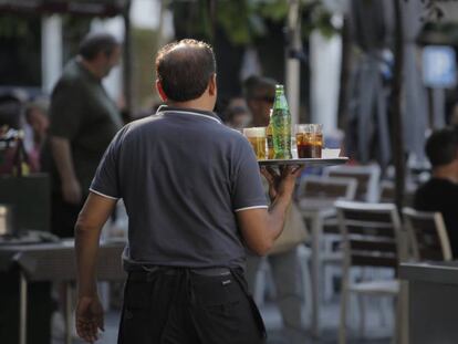 Un camarero sirviendo bebidas en una terraza en Madrid