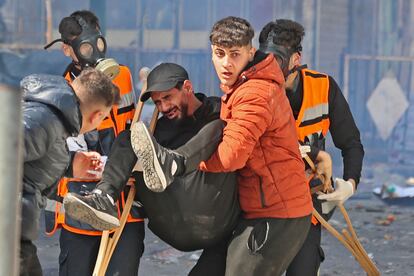 Varios jóvenes palestinos trasladan a un herido durante la redada, este miércoles en Nablus.