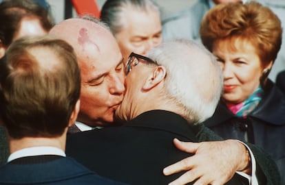 El presidente de la URSS, Mijaíl Gorbachov (a la izquierda), besa a Erich Honecker, presidente de la República Democrática Alemana, a su llegada al aeropuerto de Schönefeld, en Berlín Oriental, en una foto histórica, con motivo del 40º aniversario de la República Democrática Alemana​, en 1989. El muro de Berlín estaba a punto de caer. A la derecha, Raisa Gorbachov, esposa del exmandatario soviético.