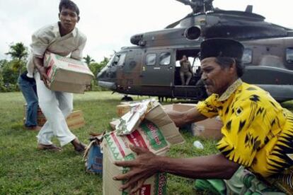 Vecinos de la provincia indonesia de Aceh, en la isla de Sumatra, recogen un cargamento de ayuda enviado por Singapur.