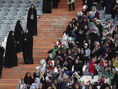 Torcedoras iranianas na grade do estádio Azadi, vigiadas por policiais.