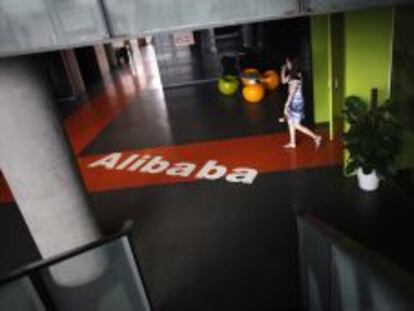 Una empleada pasa junto al logo de Alibaba en la sede de la empresa en Hangzhou (China). 