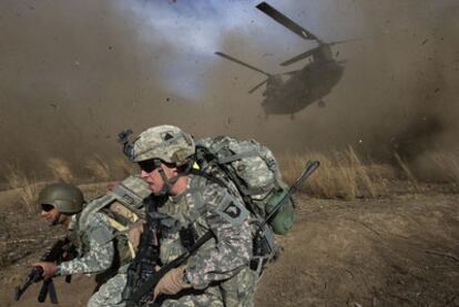 Un soldado afgano y otro de EE UU corren al llegar un helicóptero con refuerzos en una zona fronteriza con Pakistán.