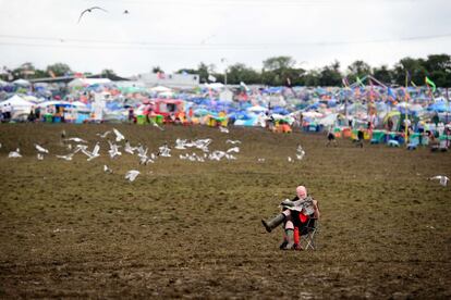 Un hombre lee un periódico en la zona de conciertos del festival, 29 de junio de 2014.