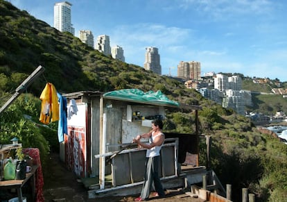 El chileno Marco Henrique, de 40 años, parchea la choza donde vive desde hace 15 años, en una colina de Viña del Mar.