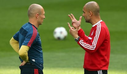 Guardiola y Arjen Robben charlan durante el entrenamiento previo al encuentro. 