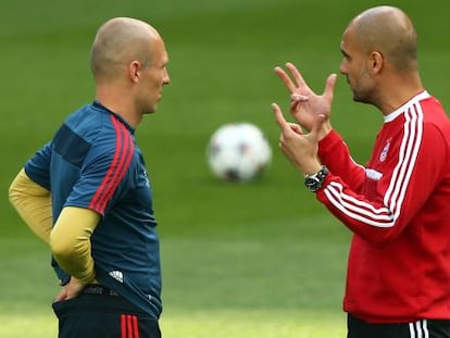 Guardiola y Arjen Robben charlan durante el entrenamiento previo al encuentro. 