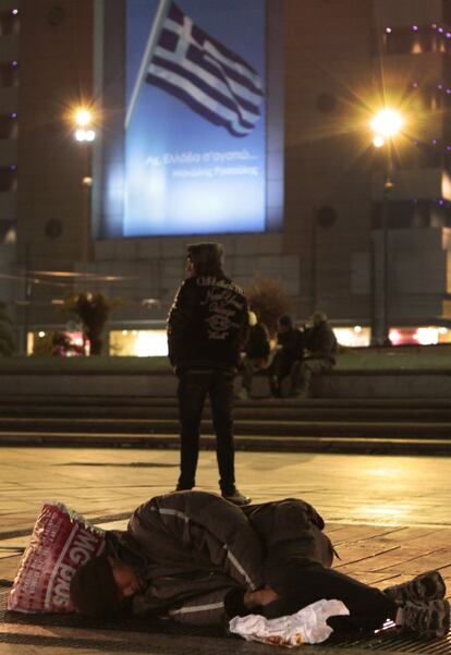 Un 'sin techo' duerme en la plaza Omonia, en el centro de Atenas.