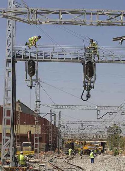 Dos operarios trabajan en la reparación de la catenaria.