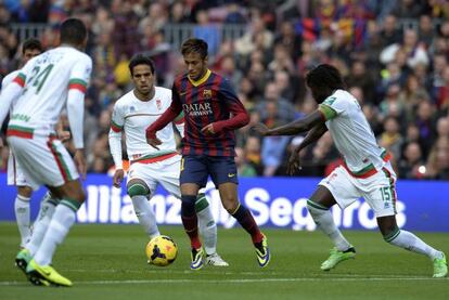 Neymar, entre dos jugadores del Granada.