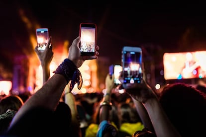 Asistentes a un festival graban con sus móviles.