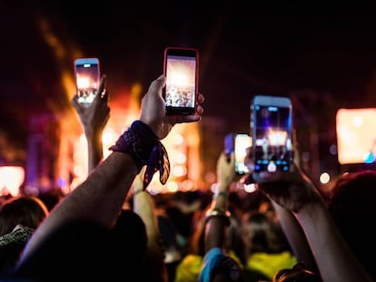 Asistentes a un festival graban con sus móviles.