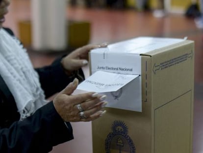 Uma mulher deposita seu voto em Buenos Aires.