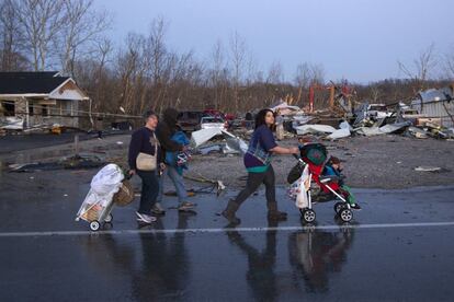 Una familia camina entre las runias de Henryville (Indiana) este viernes