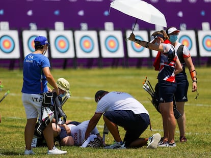 Svetlana Gomboeva é atendida durante a prova de tiro depois de desmaiar devido à insolação.