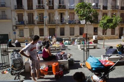 Vecinos desalojados ayer vigilan sus pertenencias en una plaza de Málaga.