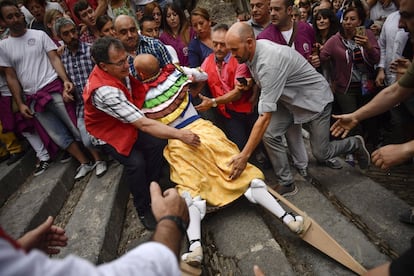 La gente ayuda a un danzador que se ha caído durante la celebración de la fiesta.