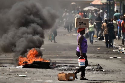 Una mujer pasa junto a una barricada en la comuna de Petion Ville, el 17 de febrero. 