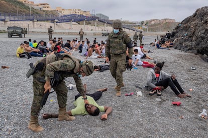 Un migrante es asistido por soldados del Ejército español en el enclave español de Ceuta, el pasado 8 de mayo.