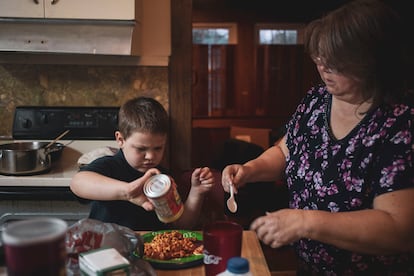 A woman fixes dinner for her kids.
