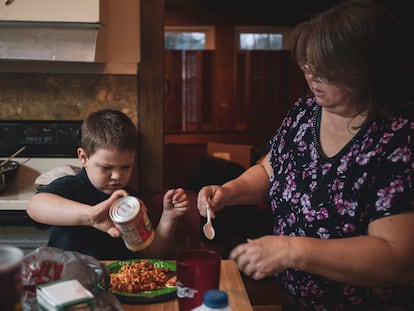 A woman fixes dinner for her kids.