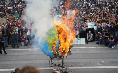 Los estudiantes queman una réplica del planeta Tierra durante la huelga por el clima en Milán, Italia.