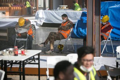 Varios operarios, algunos de ellos con mascarillas sanitarias, parados en un patio del recinto de Fira Barcelona.