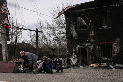 Un grupo de gente se protege de los bombardeos en la ciudad de Bucha, al oeste de Kiev