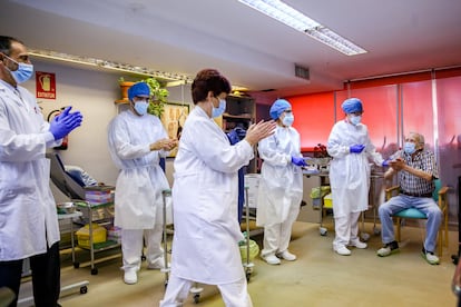 Healthcare workers applaud Nicanor, 72, after he became the first man to receive the Covid-19 vaccine in the Madrid region on Sunday.