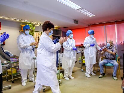 Healthcare workers applaud Nicanor, 72, after he became the first man to receive the Covid-19 vaccine in the Madrid region on Sunday.