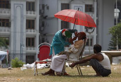 Un hombre se afeita en la calle frente al edificio del Parlamento en Islamabad, Pakistán.