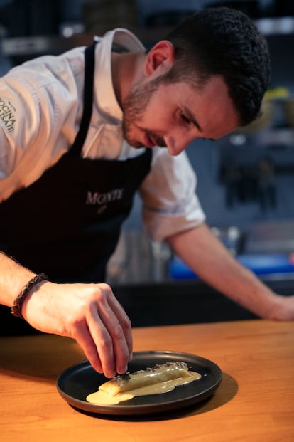 El cocinero Xune Andrade termina su canelón de corderu ‘xaldu’, reducción de leche de oveja y jugo de caldereta, semillas y hojas aromáticas, en la cocina de su restaurante asturiano Monte.