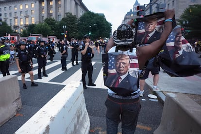 Un simpatizante de Donald Trump manifiesta su apoyo durante el paso de la policía metropolitana de Washington D. C.