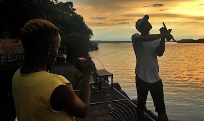 Dos turistas se hacen fotos durante el atardecer a orillas del r&iacute;o Chobe, frontera natural entre Botsuana y Namibia.