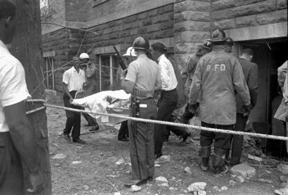 Firefighters and ambulance attendants remove a covered body from the 16th Street Baptist Church in Birmingham, Ala., Sept. 15, 1963