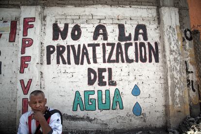 Un hombre frente a un letrero en protesta de la privatización del agua en México.