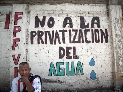 Un hombre frente a un letrero en protesta de la privatización del agua en México.