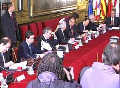 Una trabajadora del Senado entrega un aparato al presidente de La Rioja, Pedro Sanz (tercero por la derecha).