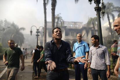 Un egipcio protesta delante de un edifico del gobierno en Giza que ha sido incendiado por manifestantes favorables al depuesto presidente Mohamed Morsi.